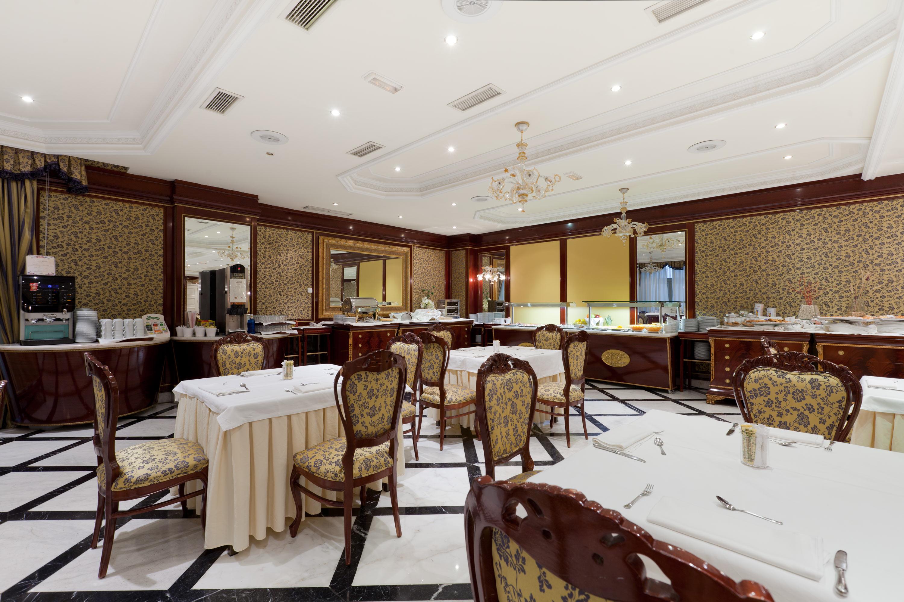 ホテル オテル アラメーダ パラス サラマンカ エクステリア 写真 The photo depicts an elegant dining room in a restaurant. The interior features ornate decorations, including patterned wallpaper and a sophisticated chandelier hanging from the ceiling. There are several well-arranged tables, each with white tablecl